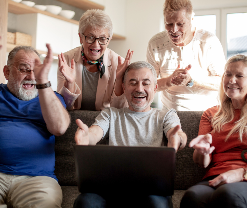 group of old friends watch a video on their laptop group of old friends watch a video on their laptop